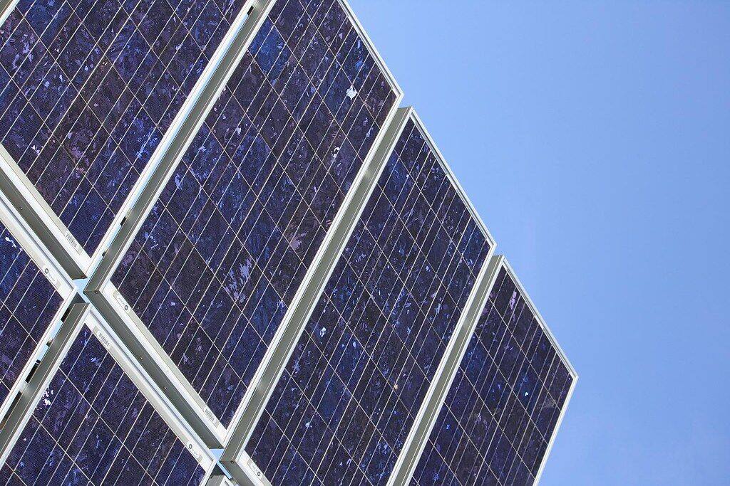 Solar panel array angled towards a clear blue sky